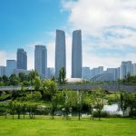 The towers of the Chengdu Financial Centre seen across parkland