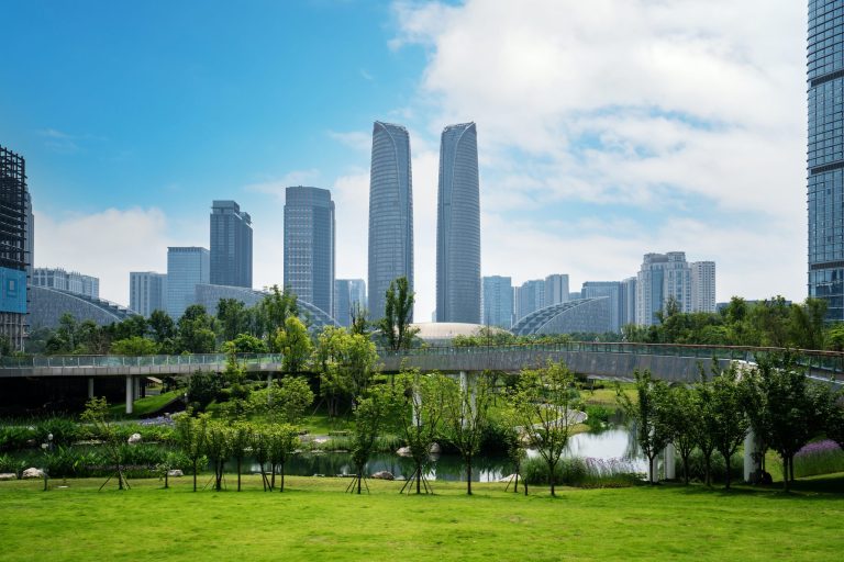 The towers of the Chengdu Financial Centre seen across parkland