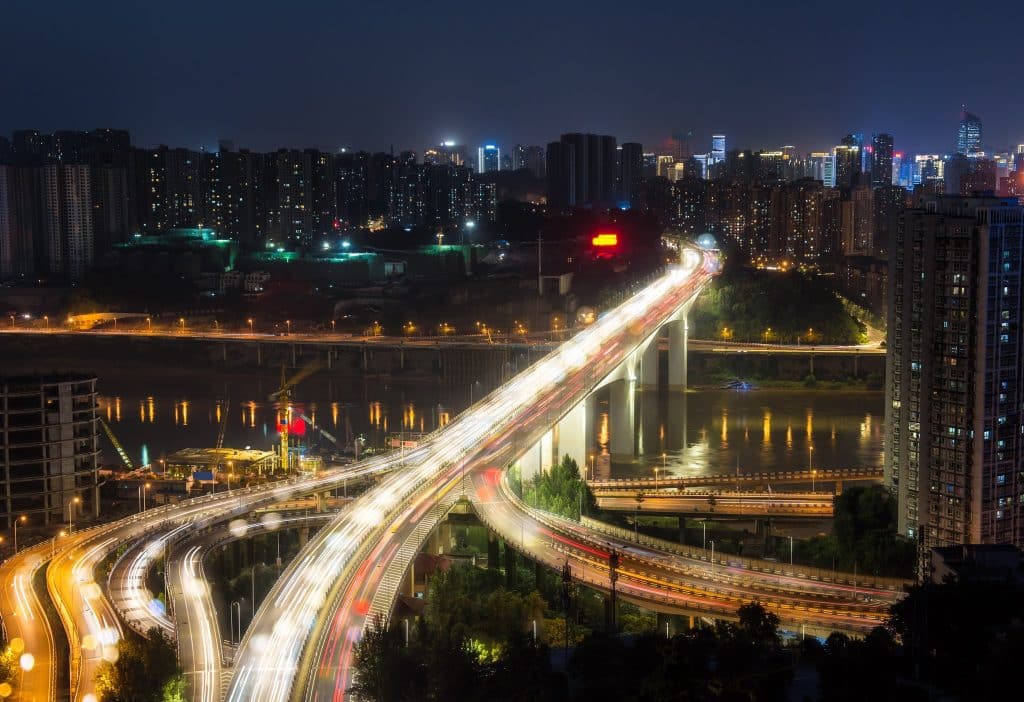 Multi-level elevated highway interchange at night in Chongqing, light trails from traffic