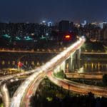 Multi-level elevated highway interchange at night in Chongqing, light trails from traffic