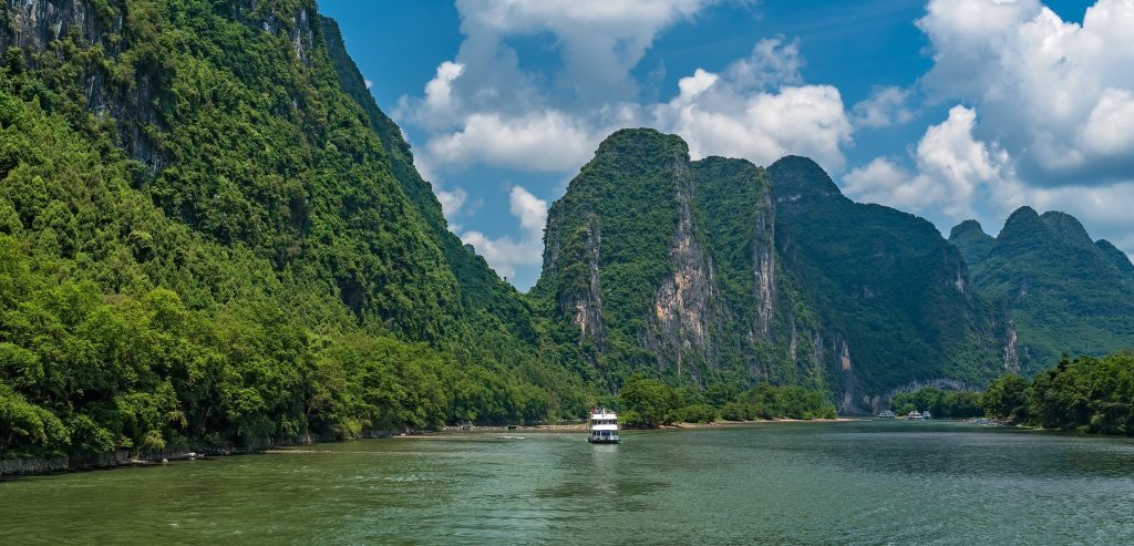A tourist cruise boat on the Li River below the karst peaks between Guilin and Yangshuo