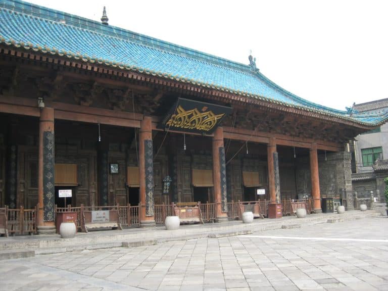 The prayer hall of the Great Mosque of Xi'an, with its turquoise-tiled roof and Arabic calligraphy sign