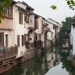 Whitewashed canal-side houses along a narrow waterway in the old Gusu district of Suzhou