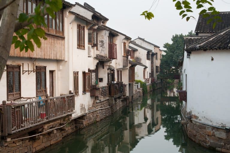 Whitewashed canal-side houses along a narrow waterway in the old Gusu district of Suzhou