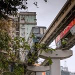 Monorail train passing through a residential building at Liziba Station in Chongqing, China