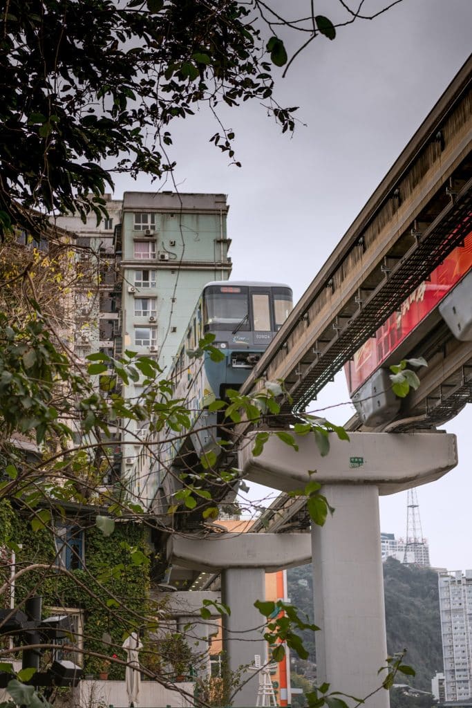 Monorail train passing through a residential building at Liziba Station in Chongqing, China