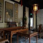 Interior of Shen Hall, a preserved Qing-dynasty merchant residence in Zhouzhuang near Suzhou, with hardwood furniture, calligraphy scrolls, and a red-tasseled lantern