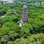 Aerial view of the leaning Tiger Hill Pagoda surrounded by forest in Suzhou