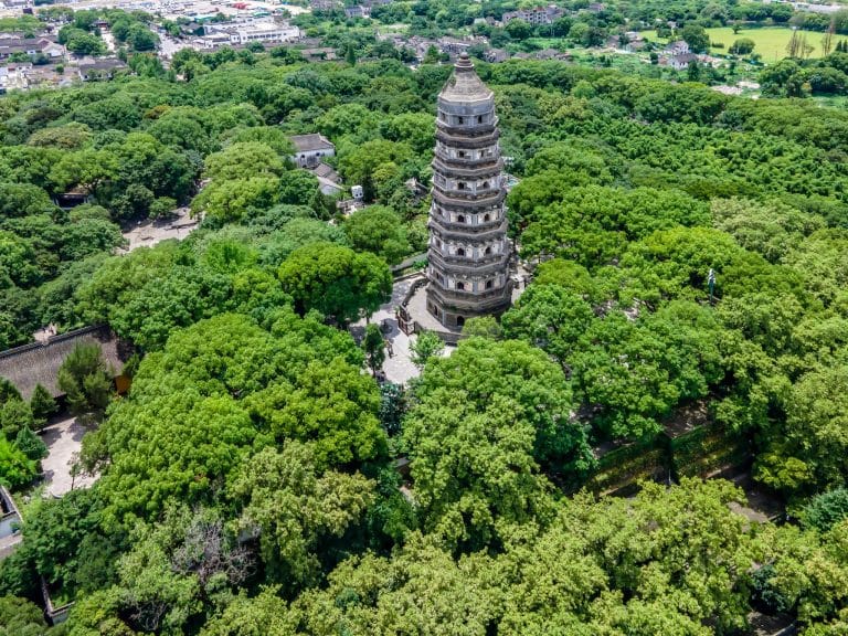 Aerial view of the leaning Tiger Hill Pagoda surrounded by forest in Suzhou