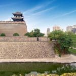 Corner watchtower of the Xi'an City Wall, with the moat below and the modern skyline behind