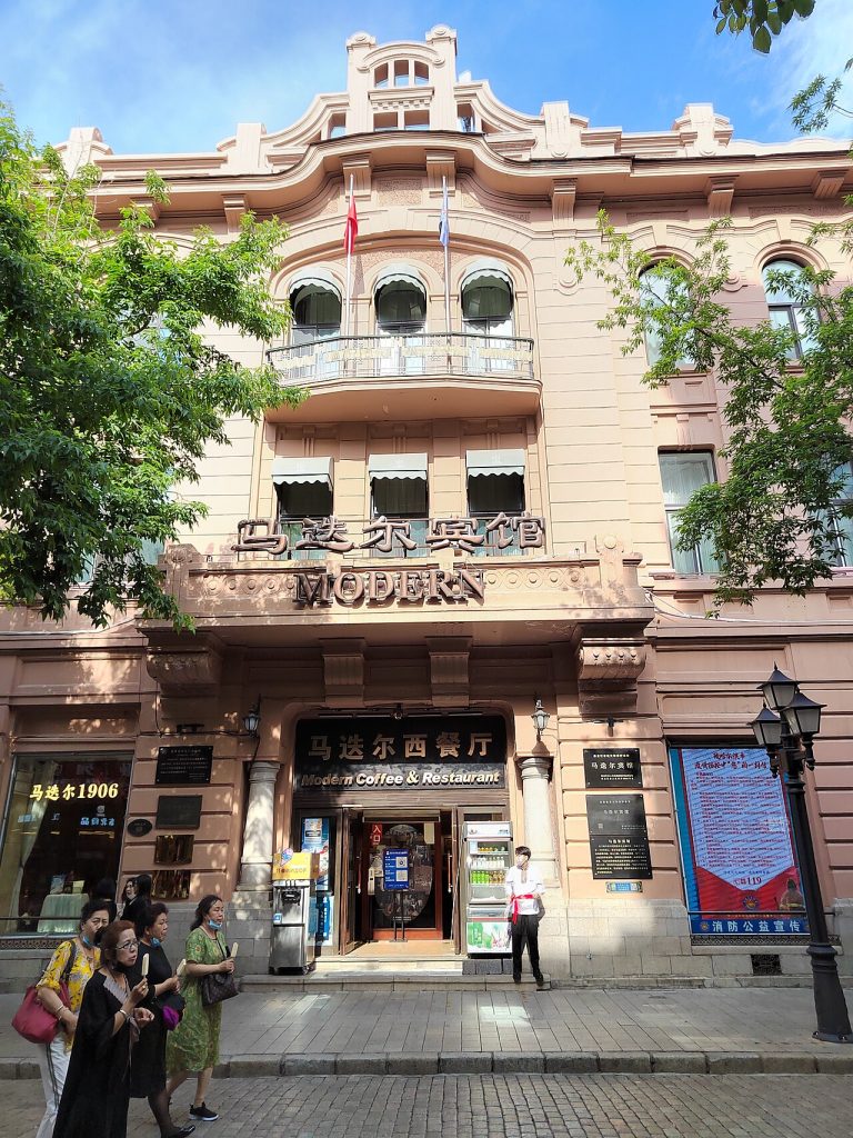 Facade of the Modern Hotel (Madieer) on Central Street, Harbin, with its MODERN sign and ground-floor cafe