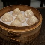 Xiaolongbao soup dumplings in a bamboo steamer basket