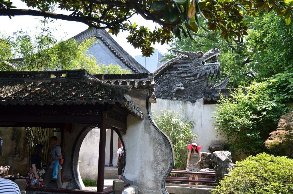 Dragon head on the ridge of a whitewashed wall above a moon gate in Yu Garden, Shanghai