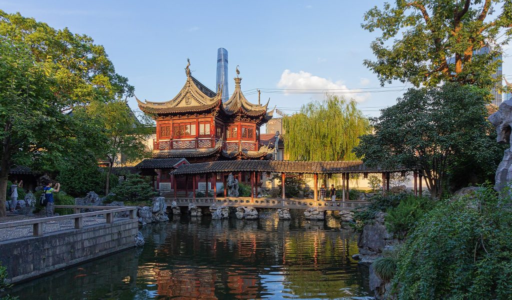 Traditional pavilion and pond in Yu Garden, with a modern tower behind, Shanghai