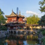 Traditional pavilion and pond in Yu Garden, with a modern tower behind, Shanghai